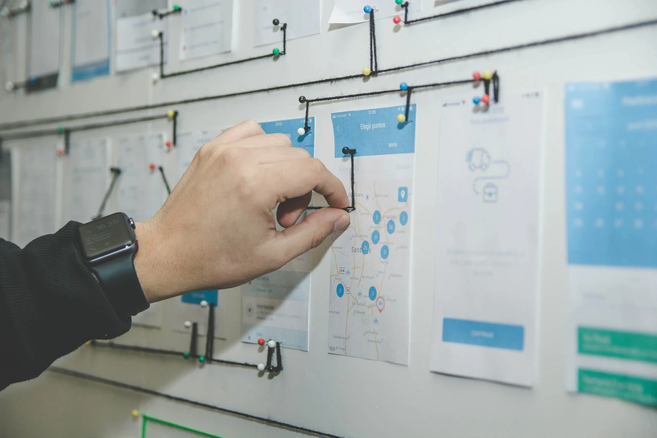 Man pinning papers on a wall